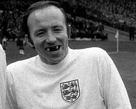 Nobby Stiles in white England shirt with the Three Lions crest smiles at the camera