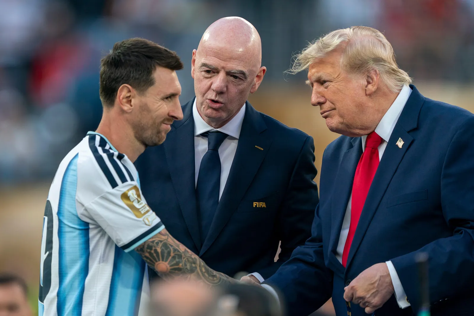 Lionel Messi shaking hands with Gianni Infantino and Donald Trump.